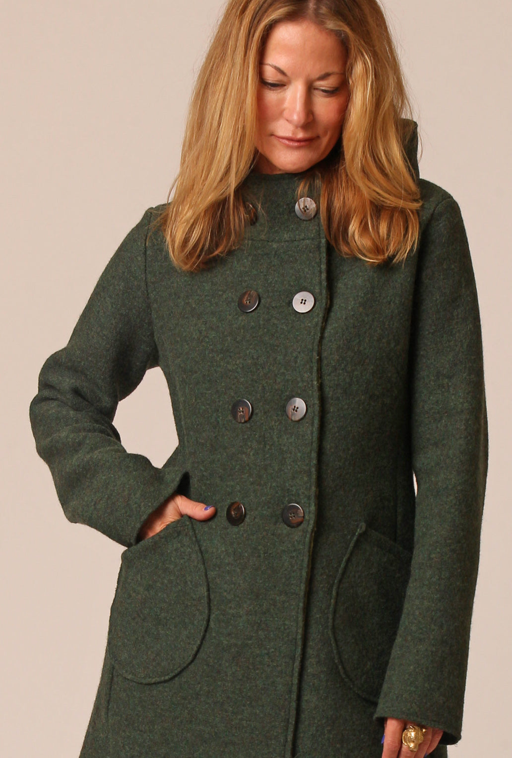 woman wearing a hooded boiled wool coat with mitten pockets double breasted buttons
