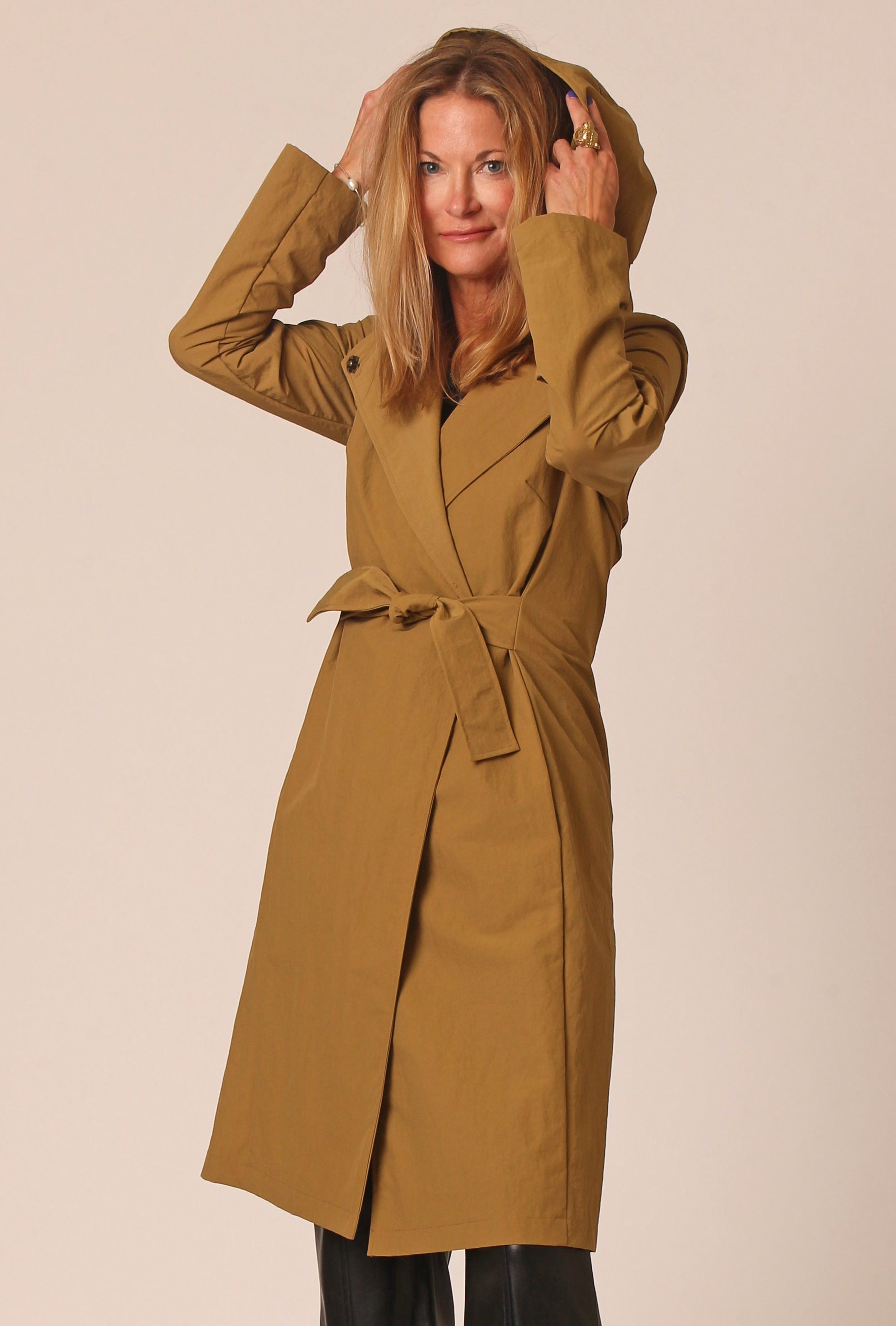 woman wearing hooded belted  waterproof rain trench in camel color